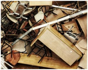 Wooden and upholstered fast furniture lying discarded in a pile.
