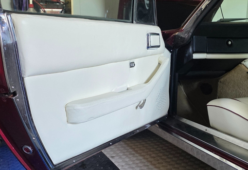 Cream leather interior trim on a car door panel.