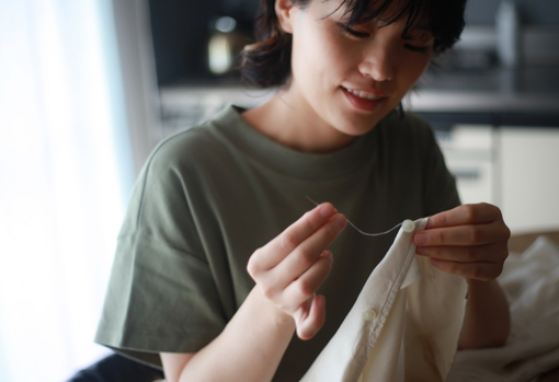 clothes mending Lady mending a shirt using some hand stitching