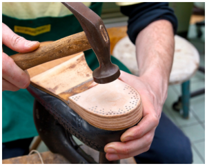 Sole of leather shoe being repaired by shoe cobbler