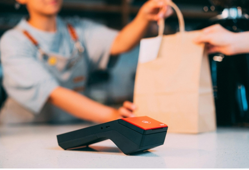 Shop owner handing over a purchased Christmas gift to customer
