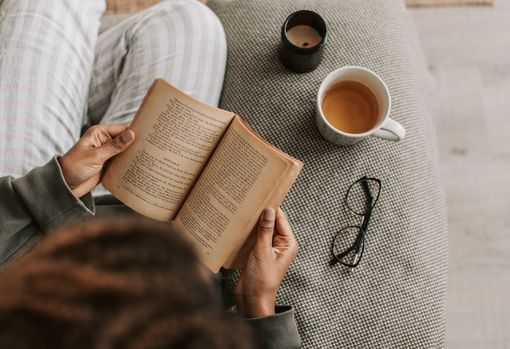 Woman curled up on the sofa, reading a book