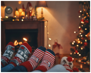 Family cosying up on the sofa in front of the fire