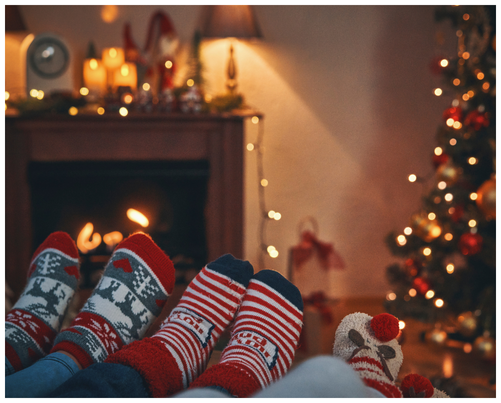 Family cosying up on the sofa in front of the fire