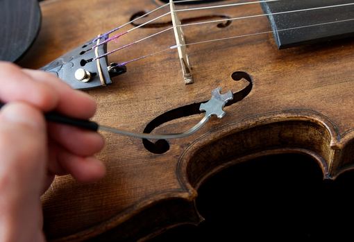 Man cleaning old violin