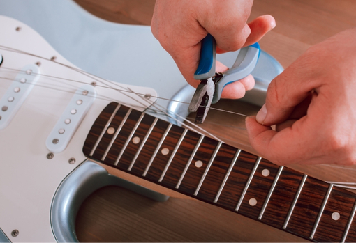Professional repairer restringing a guitar