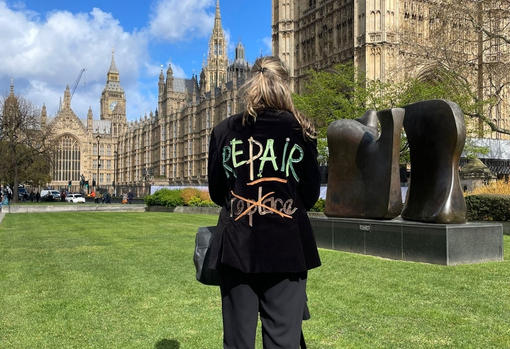 Gem stood outside Parliament wearing a black slogan jacket emblazoned with the words 'Repair don't replace'