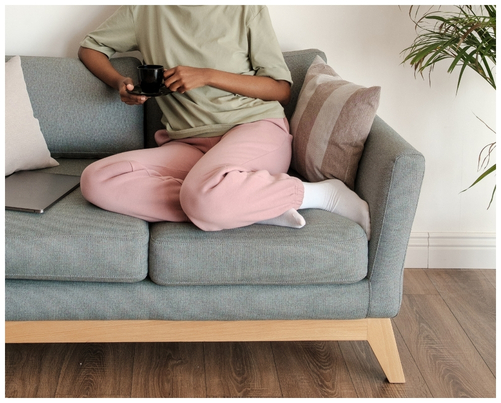 Close up of woman curled up on grey sofa